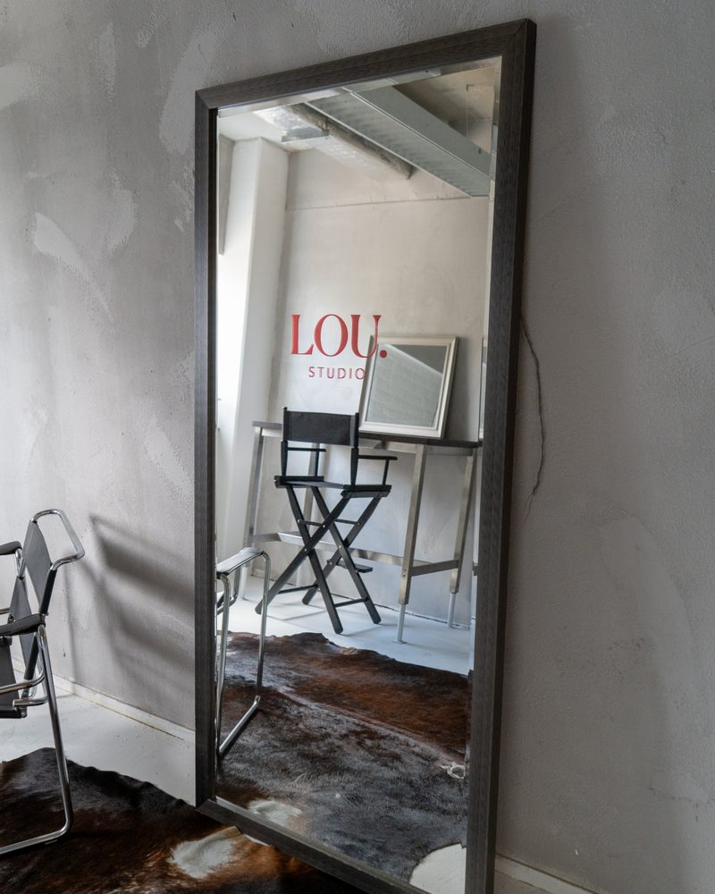 Grote spiegel met het LOU Studio-logo, regisseursstoel en visagietafel